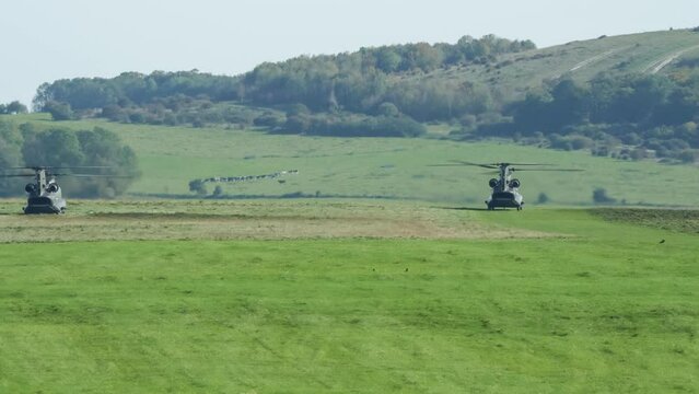 a pair of RAF Chinook tandem-rotor CH-47 helicopters transitioning from takeoff to forward flight, Wilts UK
