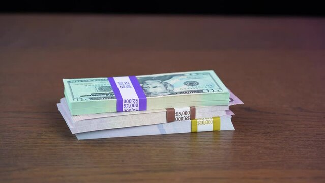 Slamming down stacks of US cash in bundles. Prop money, invalid serial numbers.  	