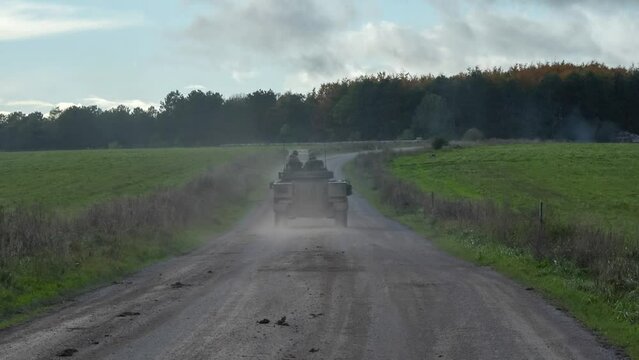 Warrior FV510 moving along a dirt road at speed, clouds of dust