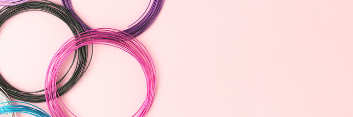 Banner with aluminum wire for jewelry making on a pink background. - obrazy, fototapety, plakaty