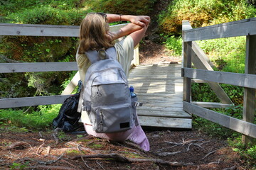 Strike a pose. Girl sitting in nature at one wooden bridge. Jämtland, Sweden.