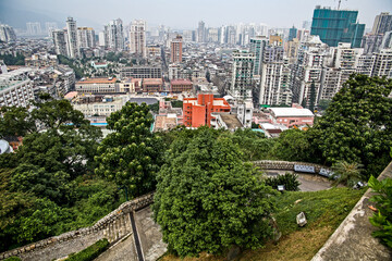 Older Portuguese buildings, a church and a cemetery surrounded by a jumble of high rise apartments,...