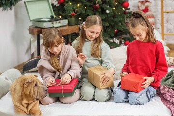Children preteen opening magic Christmas gift at home. Merry Christmas and Happy Holidays.