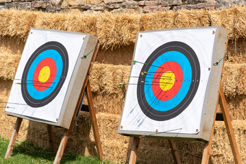 Close-up of dartboards with bales of straw behind them in a medieval street market.