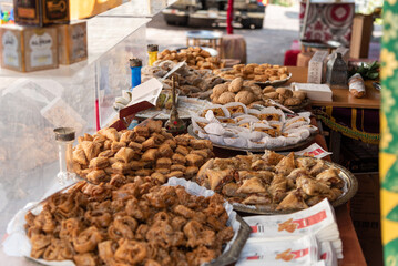 Detail shot of trays of different types of sweets and handmade products on a table at a stall in a medieval street market. Traditional products and gastronomy