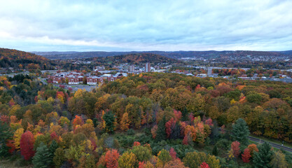 arial view of binghamton university in vestal, new york during autumn with fall foliage (leaves changing colors) at dusk, sunset, cloudy sky (library tower, student union, mountainview residence hall)