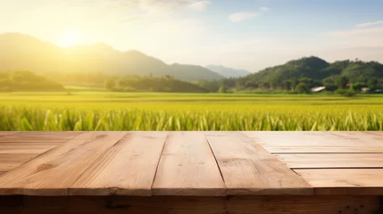 Fototapeten Empty wood table and blurred rice field and mountain landscape at morning. Empty wooden table with rice field and sunshine © Boraryn