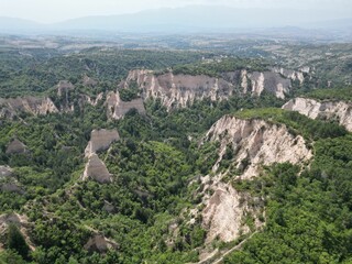 Fototapeta na wymiar Aerial shot of the pyramids of Melnik and green trees on a summer day, Bulgaria