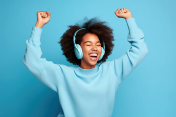 happy woman with headphones dancing isolated over blue background. - obrazy, fototapety, plakaty