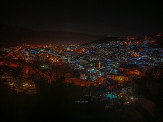Aerial view of the Chefchaouen city illuminated with colorful lights at night