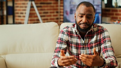Remote professional holding q a session with webinar participants via video conference meeting in cozy apartment. Online video call host engaging in online discussions with trainees