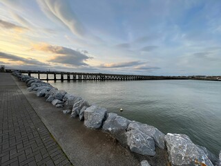 Scenic view of an ocean coast with a wooden bridge over it on a sunny day