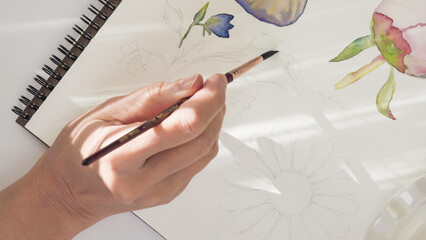 Watercolor painting. Woman draws watercolor sketches of flowers. Art, learning to draw, hobby...