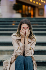 Woman holding her hands over her face feeling sad and starting to cry