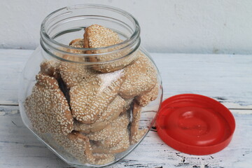 Indonesian snack called sesame ginger cookies in the shape of a heart in jar on the table