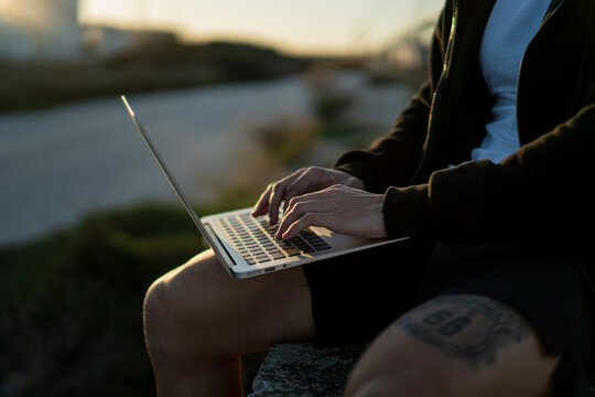 Toma detalle de port&aacute;til en el regazo de una persona en la calle mientras trabaja