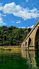 Fototapeta na wymiar Old beautiful bridge on the Drina river in Visegrad, Bosnia and Herzegovina on a sunny day