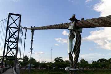 A large wire rope attached to the steel bridge.