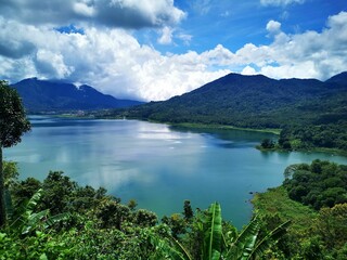 Scenic lake surrounded by valleys and a dense forest