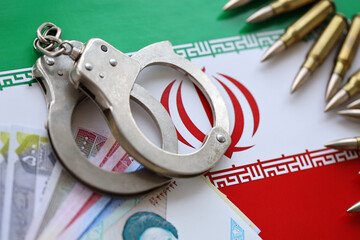 Iran flag and police handcuffs with iranian money bills rials. The concept of crime and offenses in...