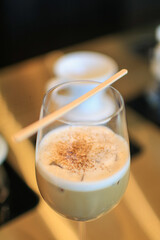 Coffee latte with milk foam in a tall glass. Summer cocktail in bar. New exotic cocktail drinks a combination of cold brew coffee with milk.