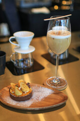 Homemade Banoffee cake and coffee latte in tall glass. English traditional pie. Sweet dessert and drink on holiday.
