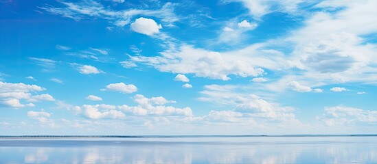Minimal nature view of Ulzhay salt lake in Omsk Russia with pastel clouds blue sky water and sandy shore
