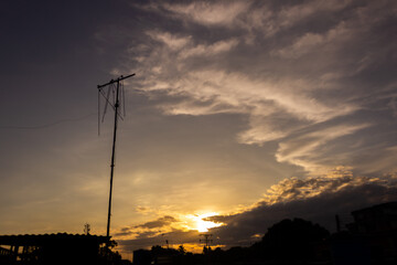 silhouette of electricity post on the sunset sky and cloud background