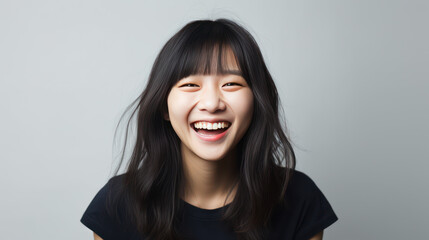 Fototapeta premium portrait of a happy asian long hair woman on grey background 