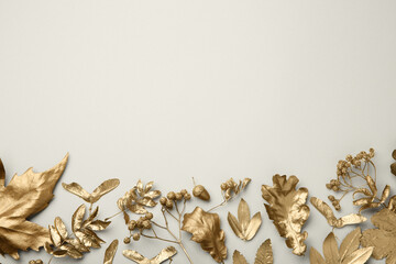 Beautiful golden leaves, berries and acorn on beige background, flat lay with space for text....