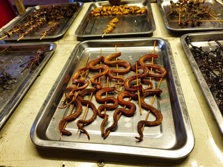 Fried snakes and worms at street food stalls in the Siem Reap's night market at Siem Reap,...