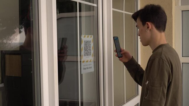 QR code on the doors at the entrance to the building. Scanning the QR code on the display using a smartphone. Internet URL, encrypted data, e-ticket, menu, contactless payment, citizen ID card, pass