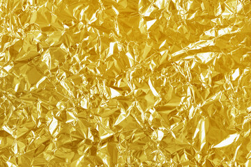 Gold foil leaf shiny texture, abstract yellow wrapping paper for background and design art work.