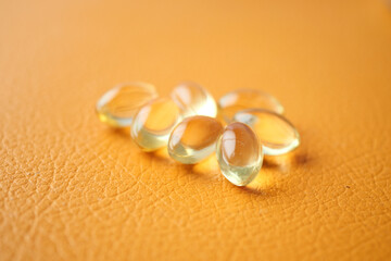 capsules from fish oil on orange color background 