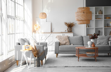 Interior of bright living room with grey sofas and vases on coffee table - obrazy, fototapety, plakaty