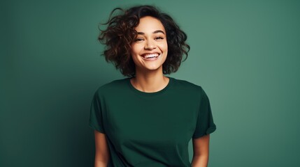 Portrait of funny young lady dressed casual t-shirt smiling on dark green background.