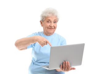 Senior woman pointing at laptop on white background