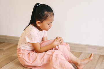 Fototapeta premium Little girl holding on knee and feeling in pain.