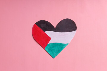 The heart shape paper with color of Palestine flag isolated on pink background
