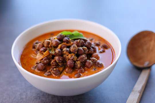Bowl of delicious Kadala curry or chana masala curry or chick pea curry in white bowl with white background. Kerala breakfast side dish for appam puttu rice. kala chana desi chana whole bengal gram