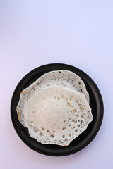 Appam, Kerala breakfast food duck curry or hot and spicy chickpea Masala and milk tea chai, Christian breakfast on dark black background. fermented rice pan cake. Top view of Indian veg food.