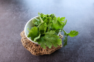 Coriander leaves fresh green cilantro on black slate background. Indian Food herbal aroma ingredient. Kerala India
