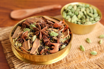 Indian spices for Indian cooking Masala for hot and spicy curry , whole spices turmeric, cardamom, black pepper in wooden spoon, star anise , paprika in Indian spice box Kerala India Sri Lanka.