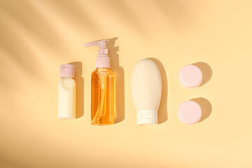 Set of travel cosmetic products on orange background