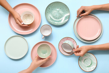 Female hands with beautiful table setting on blue background