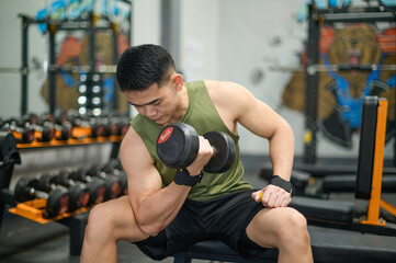 lifting a dumbbell to work the muscles in his bicep.