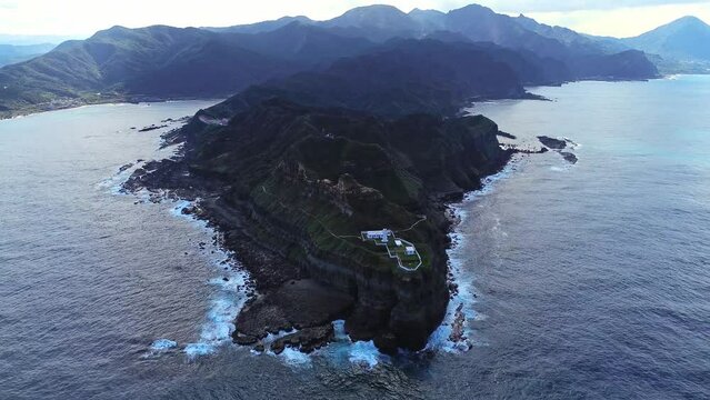 Aerial 4k footage of Bitoujiao lighthouse, a famous scenery of Taiwan northeast corner. Birds eye view in Bitoujiao cape, Ruifang district, New Taipei, Taiwan.