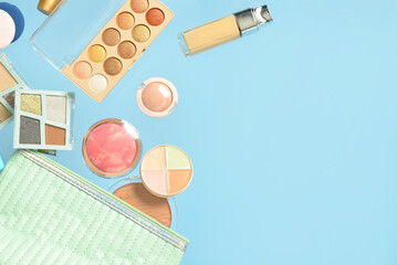 Cosmetic bag with different makeup products on blue background