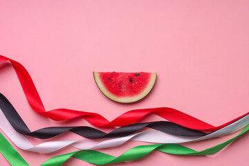Top view of watermelon slice and colorful ribbon to support Palestine on pink background.
