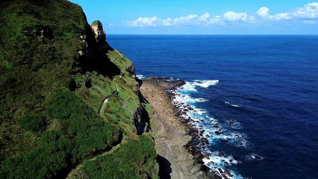 Aerial 4k footage of Bitoujiao lighthouse, a famous scenery of Taiwan northeast corner. Birds eye view in Bitoujiao cape, Ruifang district, New Taipei, Taiwan.